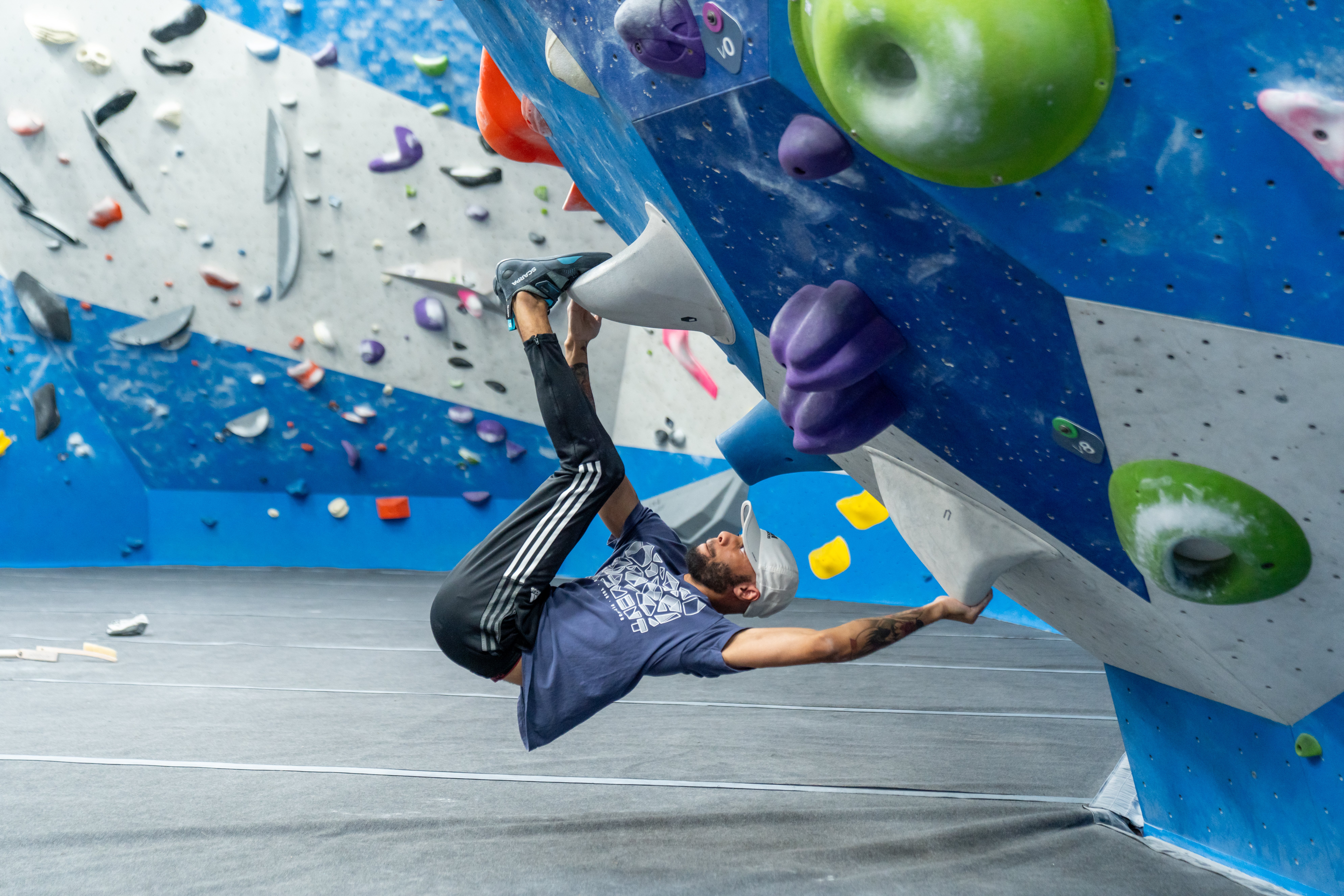 Climber using the toe hook technique while bouldering