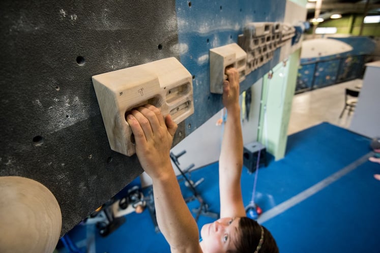 Female climber hangboarding