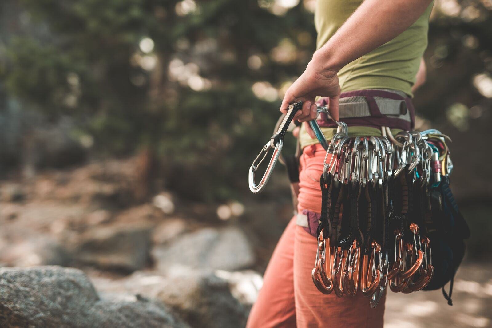 A climber racks gear on their harness 