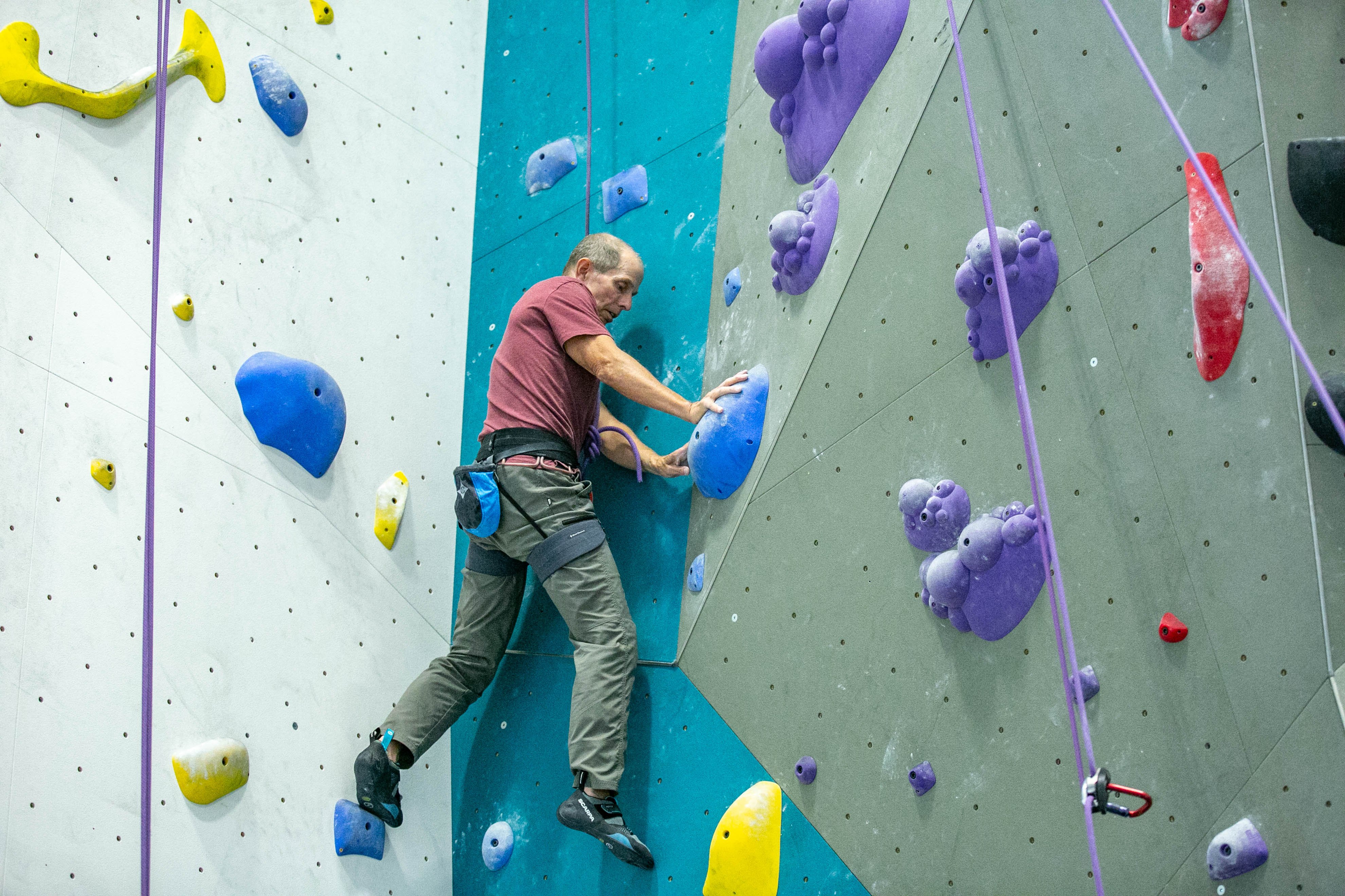Climber moving through a mantle move while climbing